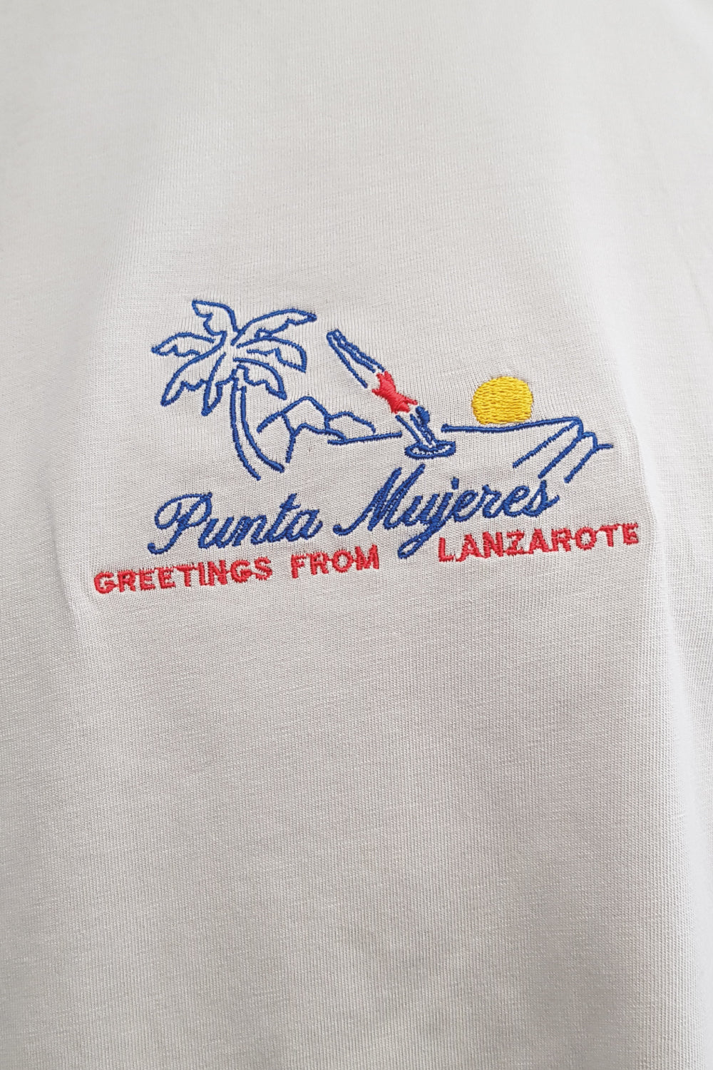 detalle bordado con escrita Punta Mujeres en el pecho de la camiseta gris en algodón orgánico sostenible