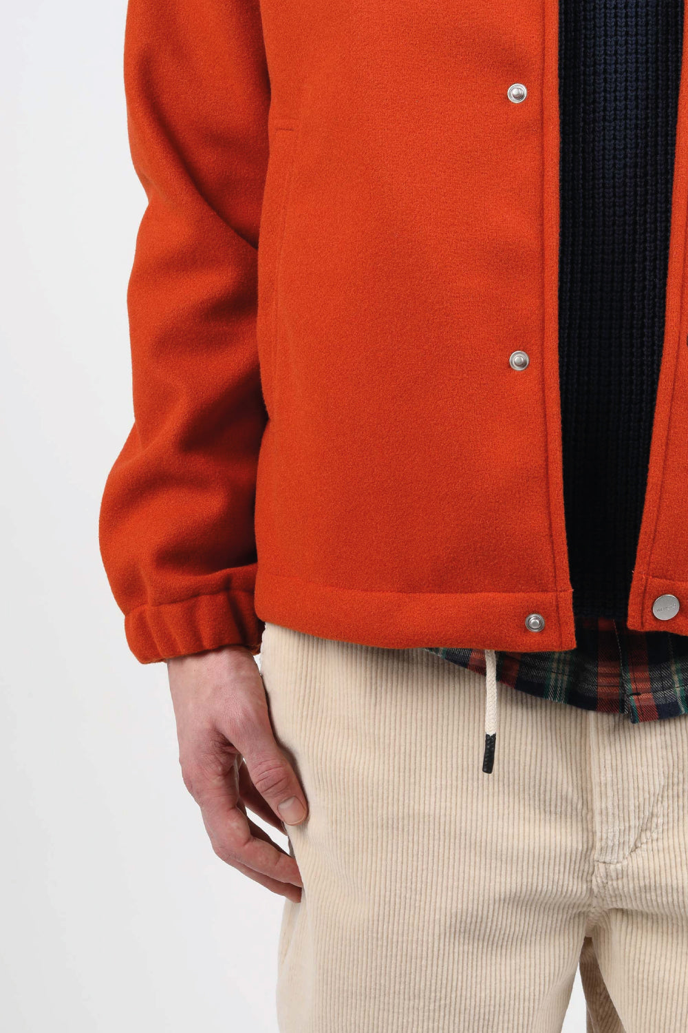 chaqueta en fieltro vegano de color naranja oxido certificado, con botones de cierre y cordones de ajuste