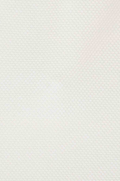 detalle del tejido en piqué en color blanco crudo con detalles de volante 