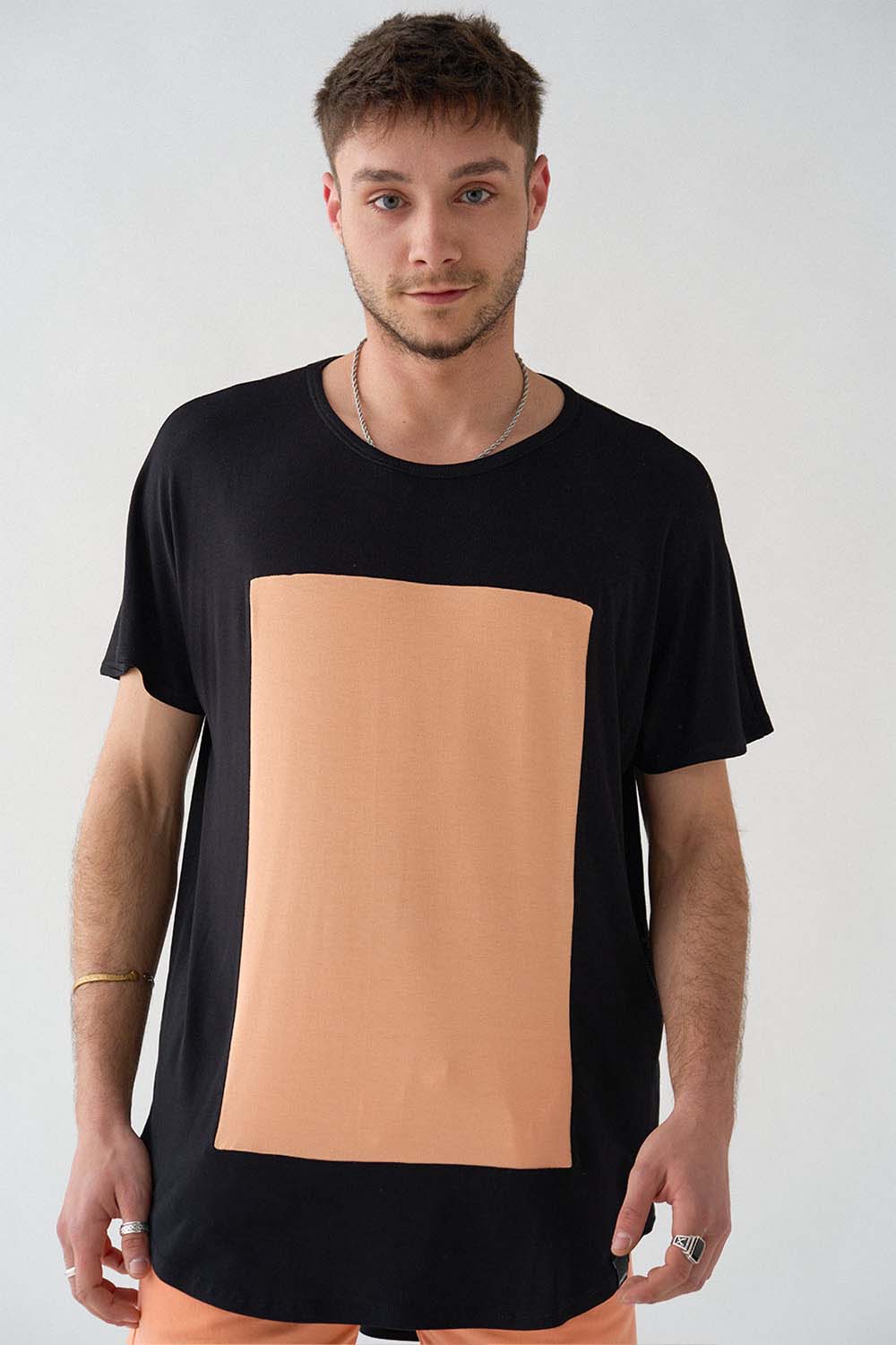 imagen detalle del modelo con camiseta quadrilaterus negro y salmón y shorts salmón