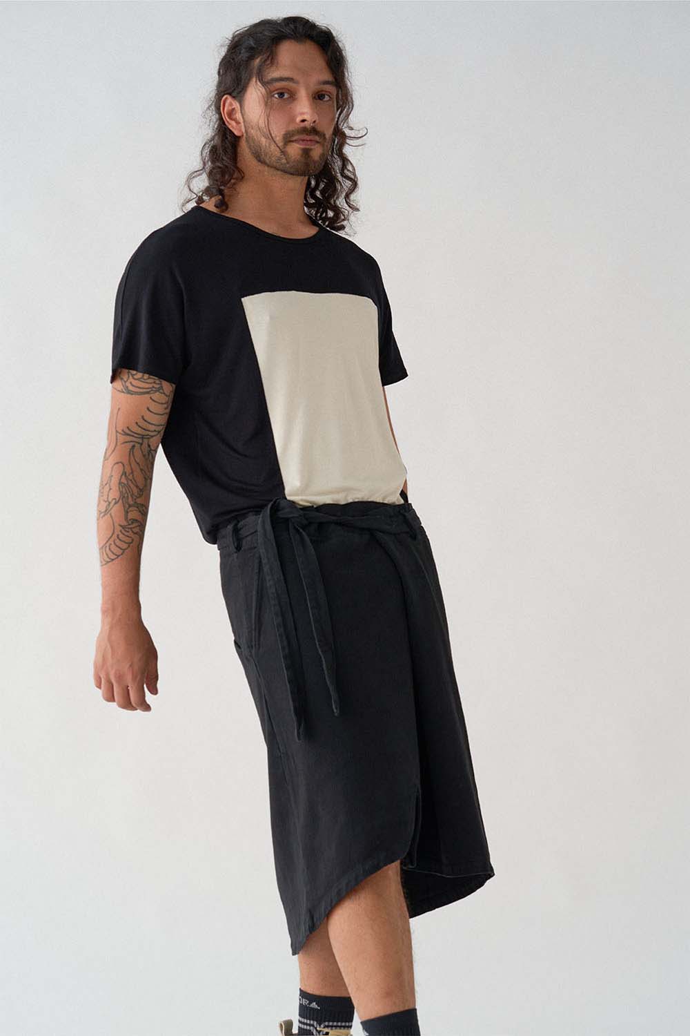 imagen  detalle del modelo con camiseta quadrilaterus negro y blanco y falda gris ceniza