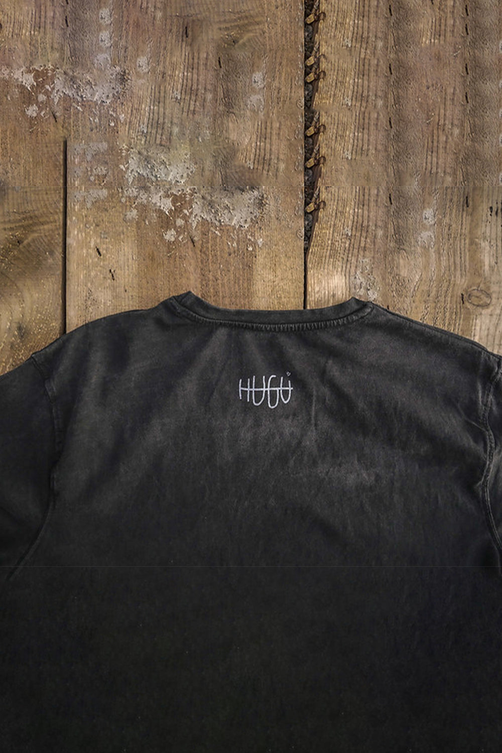 detalle del logo imprimido en la parte atrás del cuello de la camiseta muyayo en negro pizarra